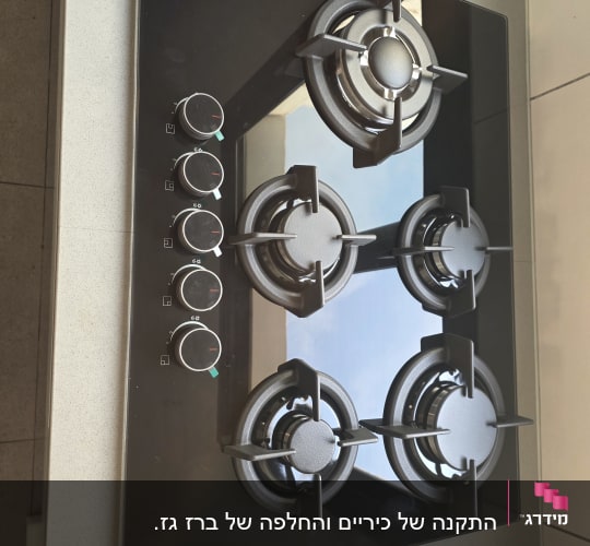 כיריים גז מזכוכית שחורה עם חמישה מבערים מותקנים במטבח